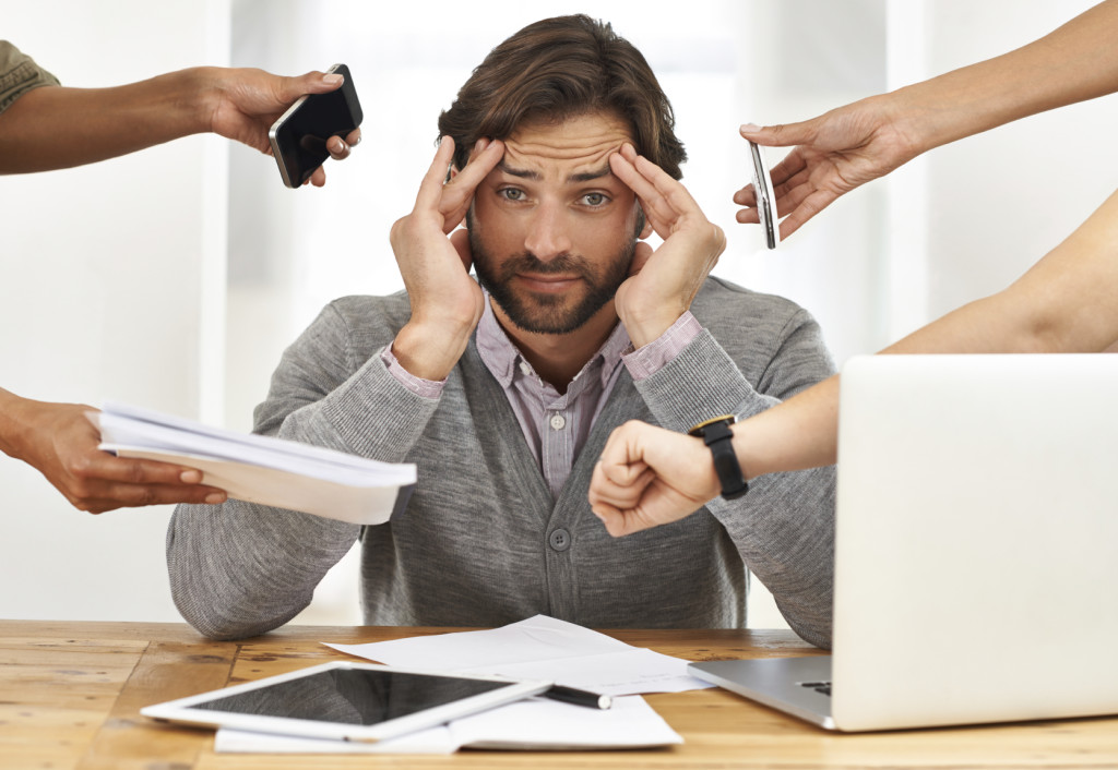 A cropped shot of a handsome businessman under strain as colleagues request various things from him